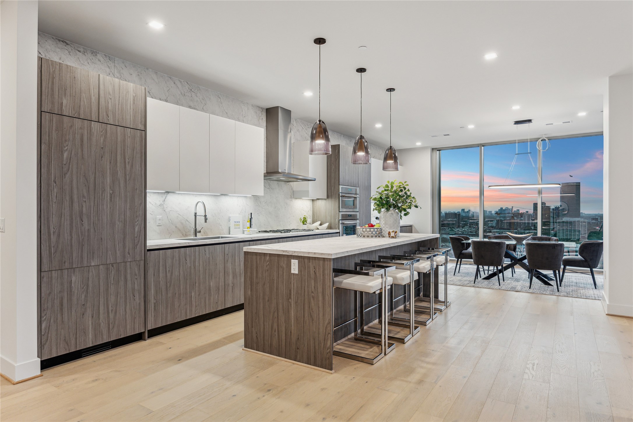1711 Allen Parkway, Unit 2301 Houston, TX 77019 - Photo 10 of 45 a kitchen with stainless steel appliances granite countertop a stove a sink a oven a dining table and chairs with wooden floor
