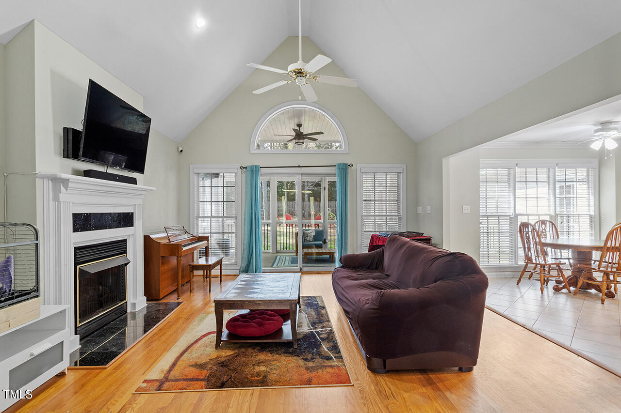 7917 Fairlake Drive Wake Forest, NC 27587 - Photo 11 of 34 a living room with furniture a fireplace and a flat screen tv