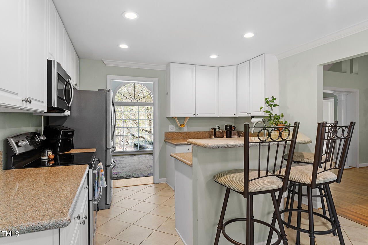 7917 Fairlake Drive Wake Forest, NC 27587 - Photo 16 of 34 a kitchen with a table chairs and a refrigerator