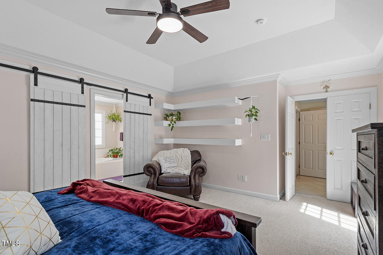 7917 Fairlake Drive Wake Forest, NC 27587 - Photo 23 of 34 a bedroom with a bed and a chandelier
