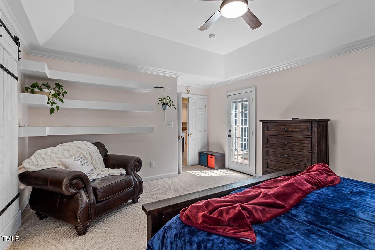 7917 Fairlake Drive Wake Forest, NC 27587 - Photo 24 of 34 a bedroom with a bed and a chandelier