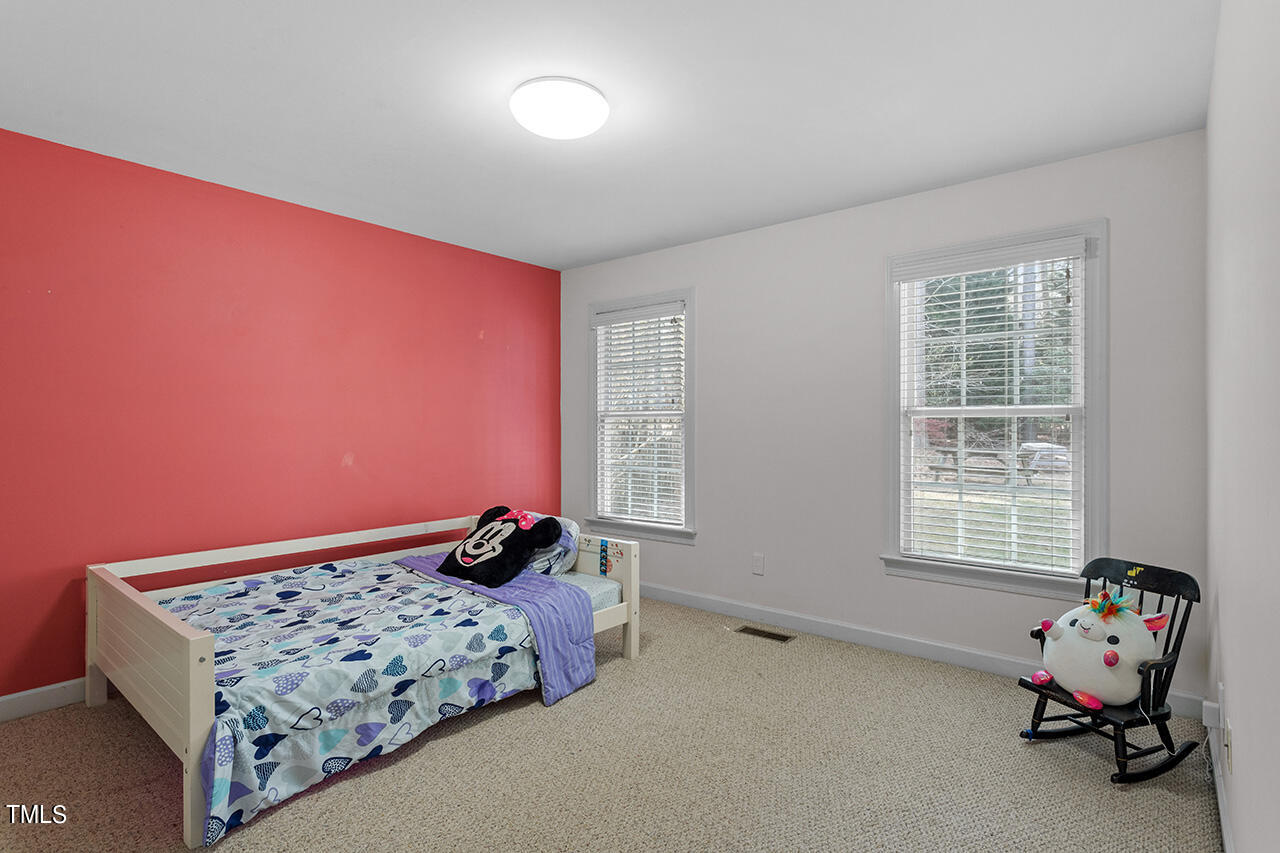 7917 Fairlake Drive Wake Forest, NC 27587 - Photo 30 of 34 a bedroom with a bed and wooden floor