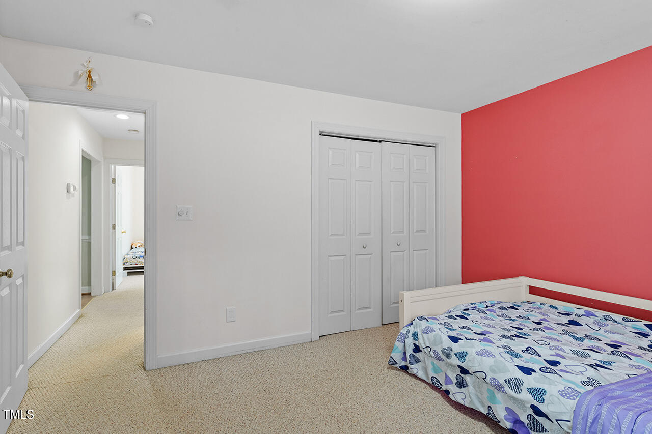 7917 Fairlake Drive Wake Forest, NC 27587 - Photo 31 of 34 a bedroom with a bed and a lamp