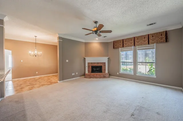 an empty room with windows and fireplace