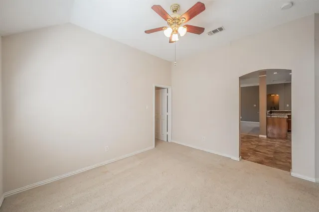 an empty room and chandelier fan