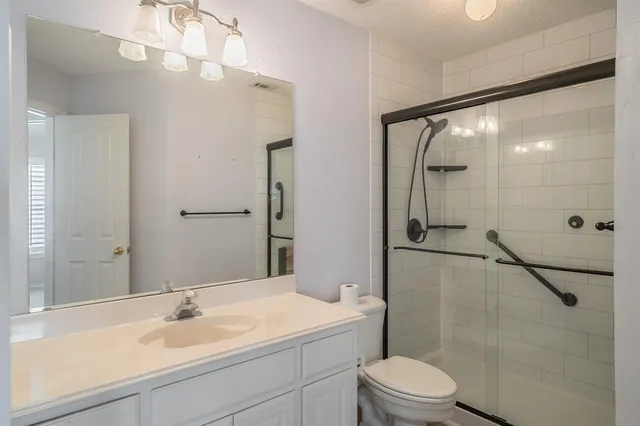 a bathroom with a sink a toilet and shower