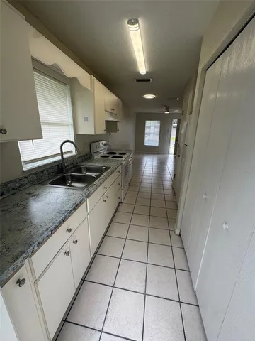 a kitchen with granite countertop a sink a stove and cabinets