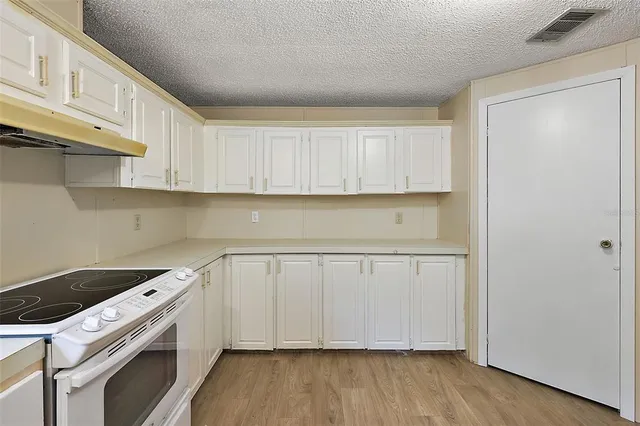a kitchen with a sink a stove and cabinets