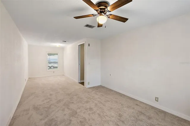 en empty room with closet and a ceiling fan