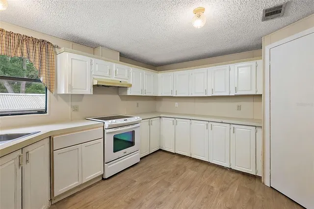 a kitchen with white cabinets white stainless steel appliances and sink