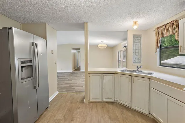 a bathroom with a sink a large mirror and a refrigerator