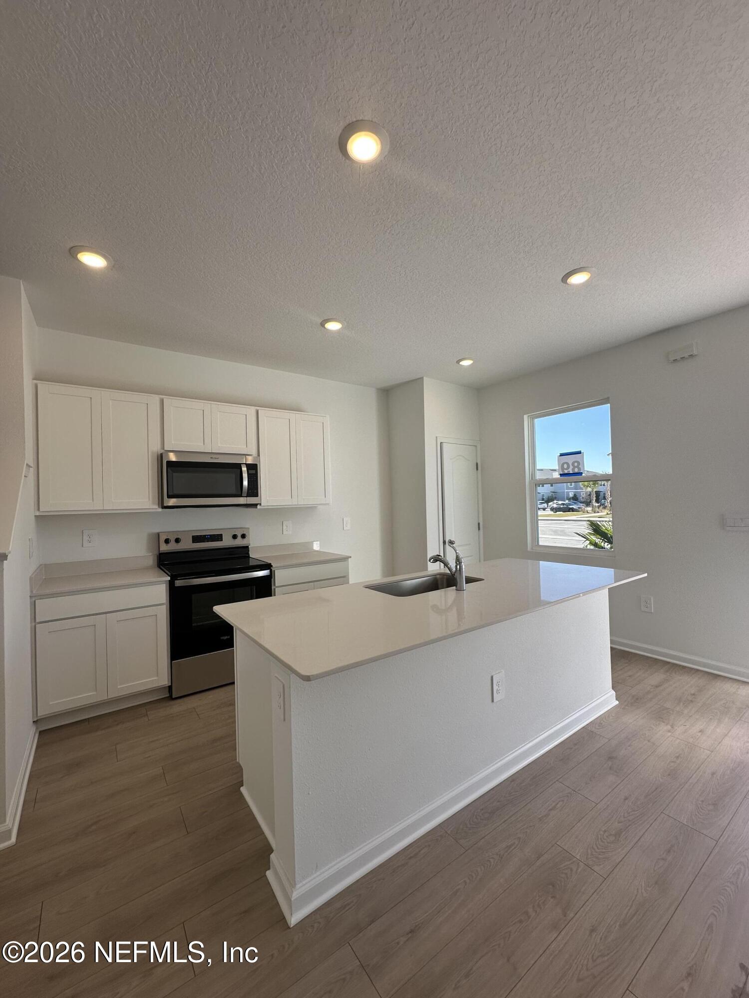 141 Palmetto Rdg Road St. Augustine, FL 32095 - Photo 7 of 43 a kitchen with a sink and white appliances