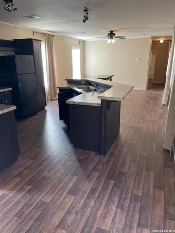 a kitchen with stainless steel appliances granite countertop a sink a stove a refrigerator and wooden floor