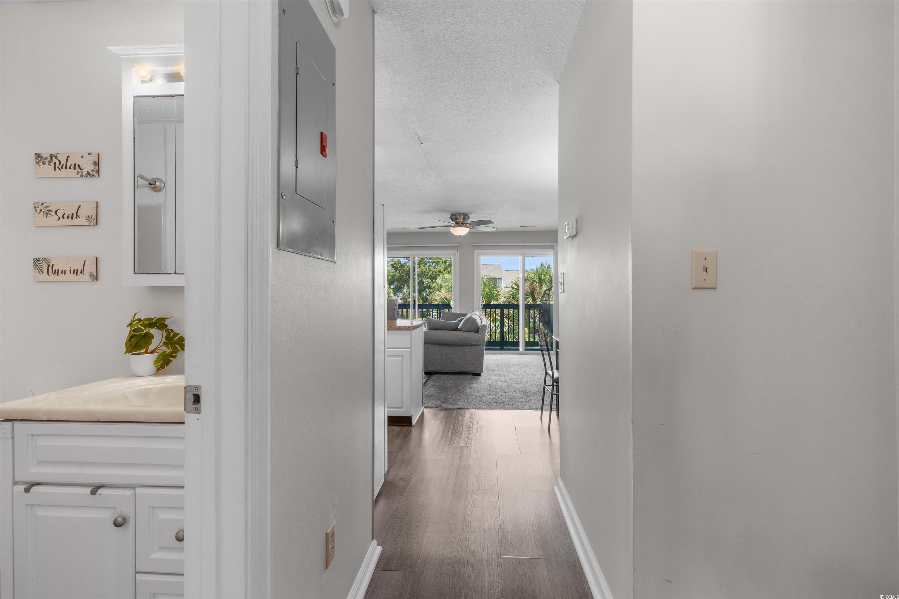 1850 Colony Drive, Unit 3D Surfside Beach, SC 29575 - Photo 11 of 38 Hall with electric panel, a textured ceiling, and dark wood-type flooring