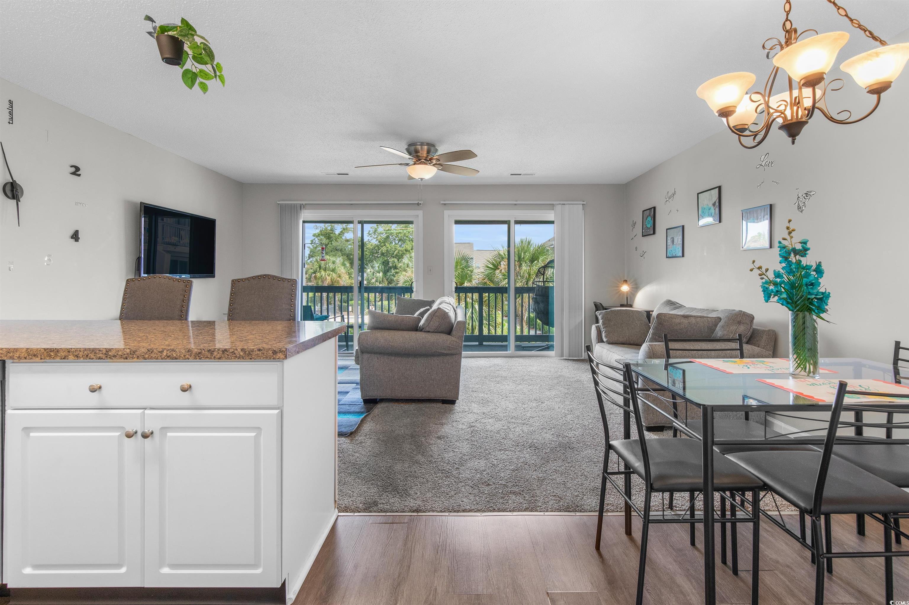 1850 Colony Drive, Unit 3D Surfside Beach, SC 29575 - Photo 13 of 38 Dining space with dark wood-style floors, ceiling fan, a chandelier, and dark carpet