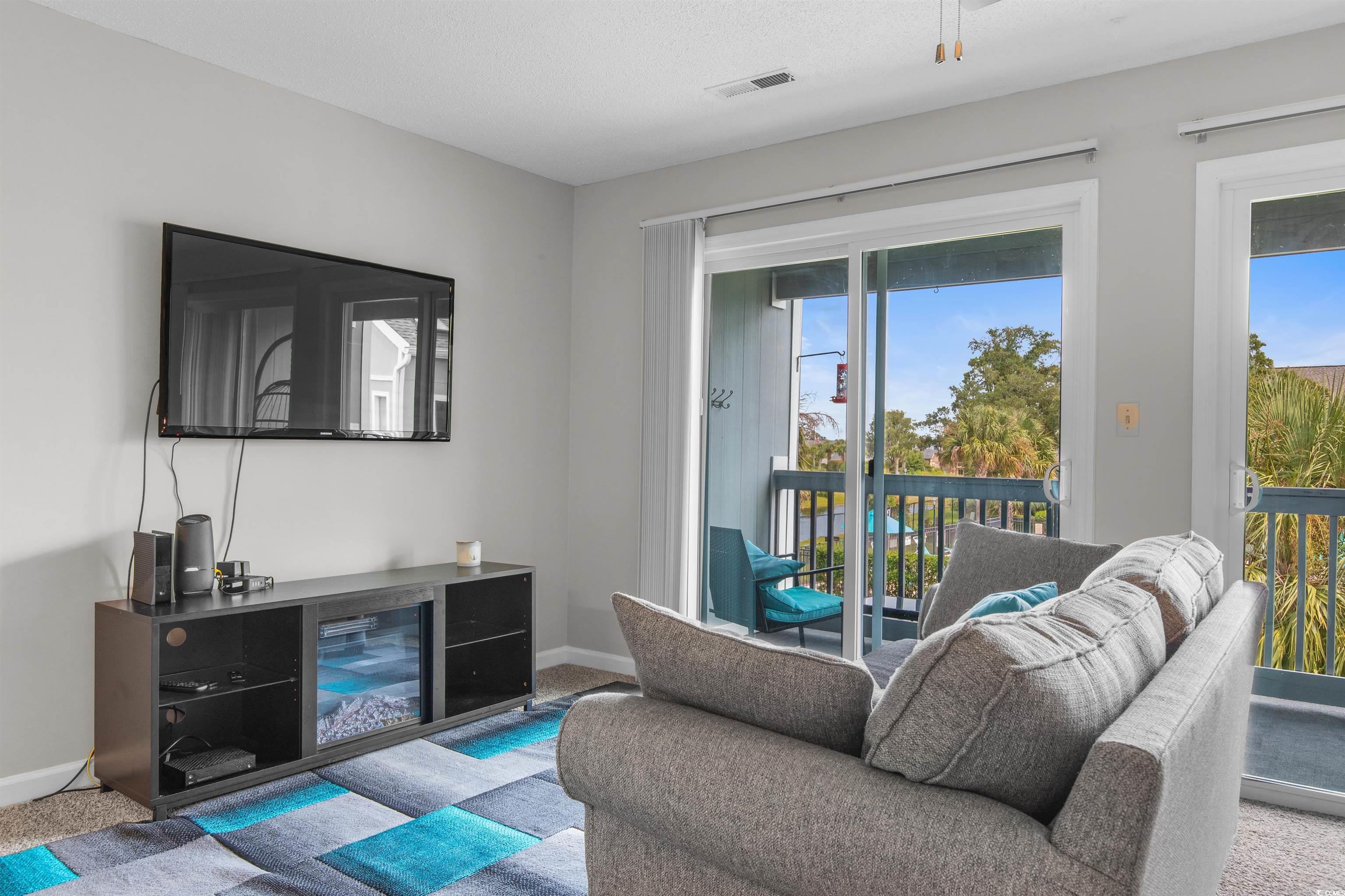 1850 Colony Drive, Unit 3D Surfside Beach, SC 29575 - Photo 18 of 38 Carpeted living area with baseboards