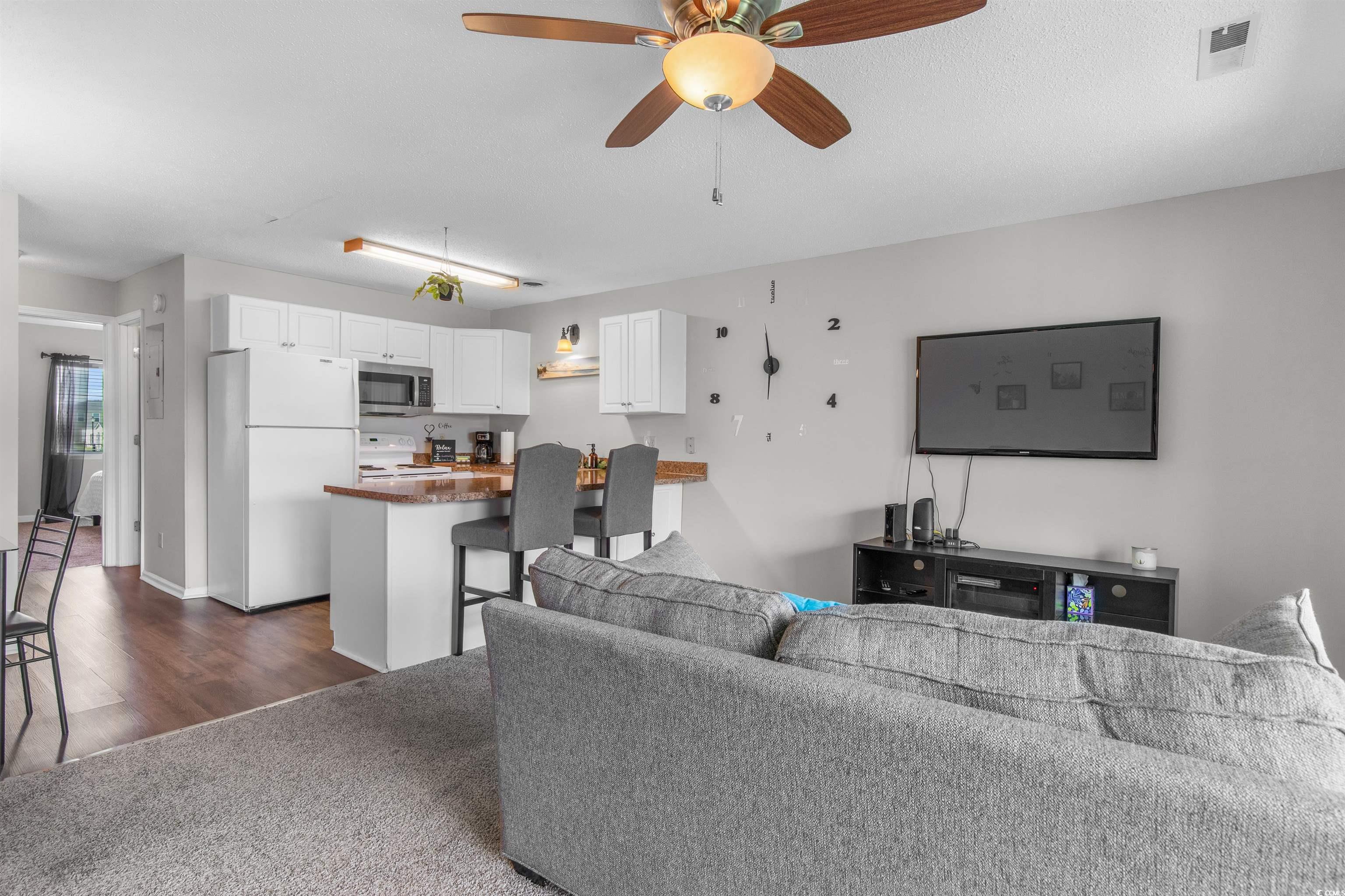 1850 Colony Drive, Unit 3D Surfside Beach, SC 29575 - Photo 21 of 38 Living area with dark carpet and ceiling fan