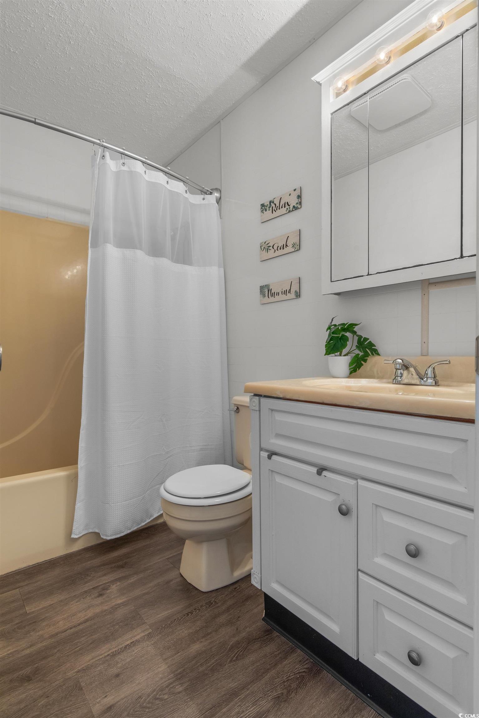 1850 Colony Drive, Unit 3D Surfside Beach, SC 29575 - Photo 10 of 38 Bathroom with dark wood finished floors, a textured ceiling, vanity, and shower / bath combination with curtain