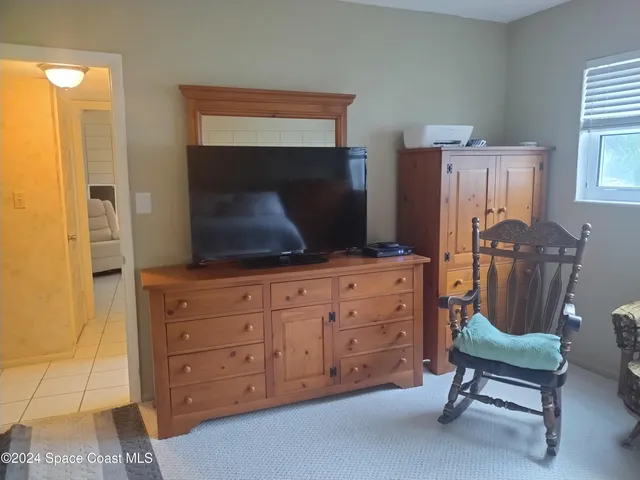 a living room with furniture closet and a flat screen tv
