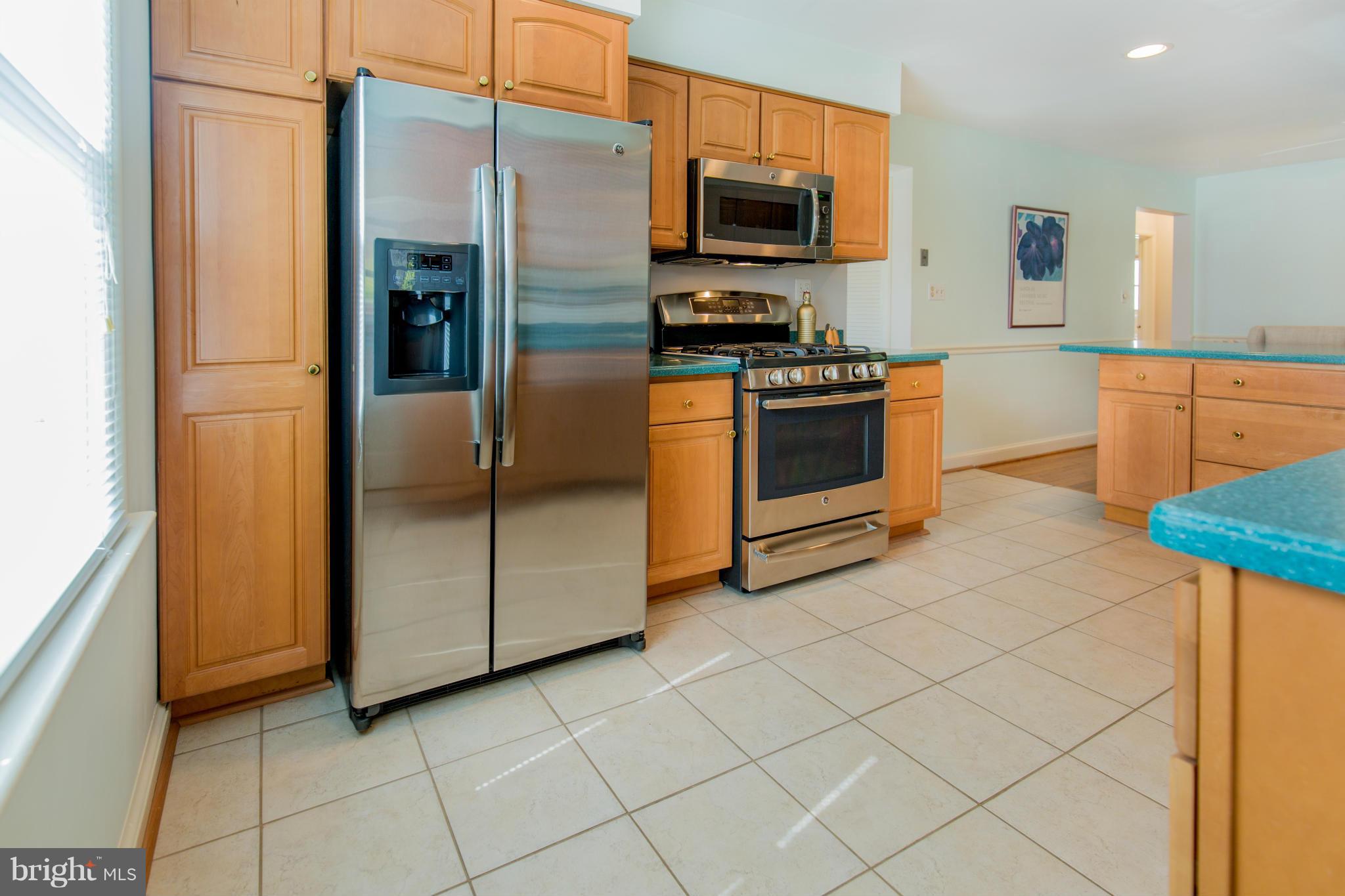 9601 Lorain Avenue Silver Spring, MD 20901 - Photo 11 of 30 a kitchen with stainless steel appliances a stove a microwave and a refrigerator