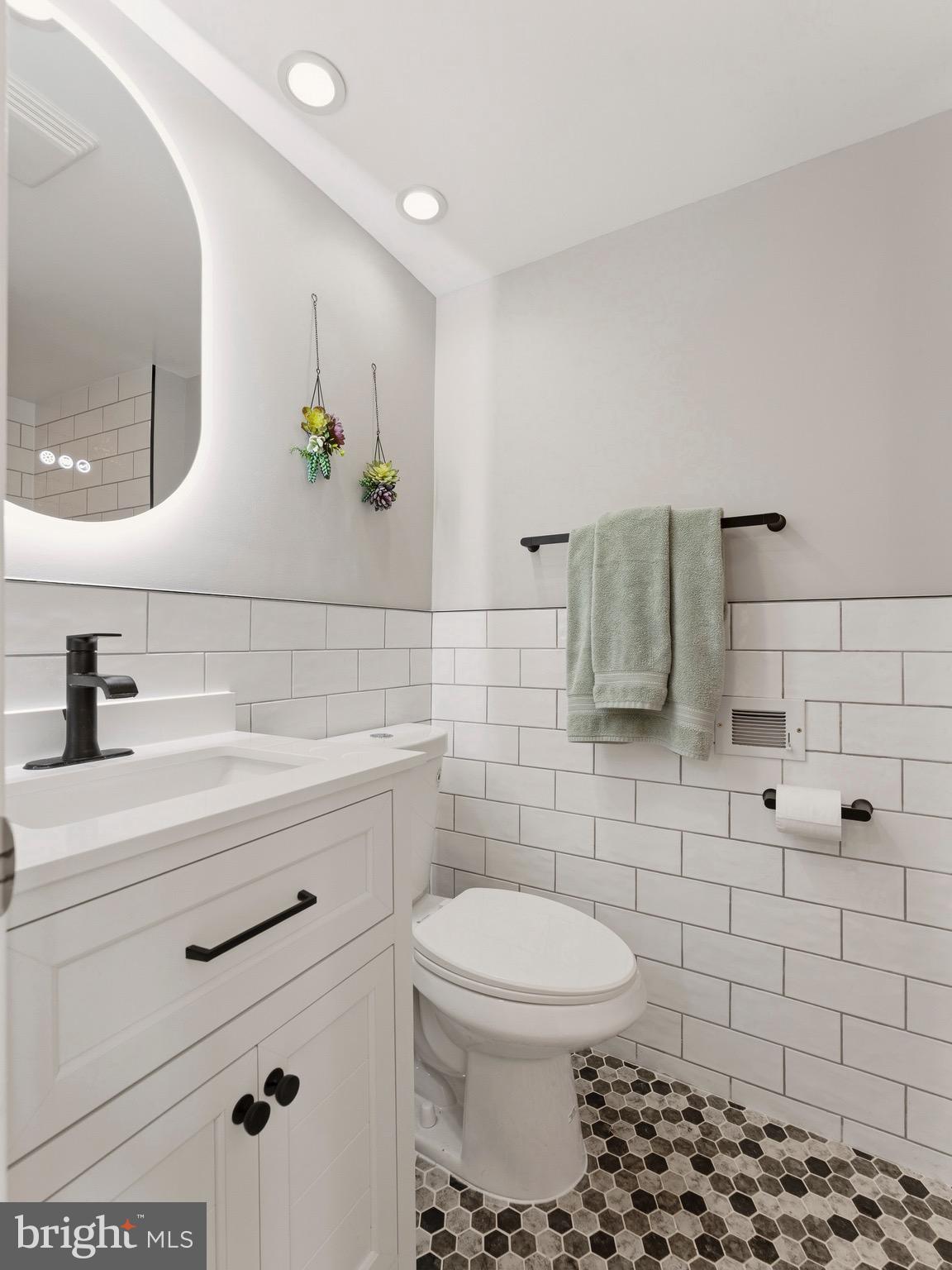 13744 Lockdale Road Silver Spring, MD 20906 - Photo 27 of 37 a bathroom with a toilet sink and mirror