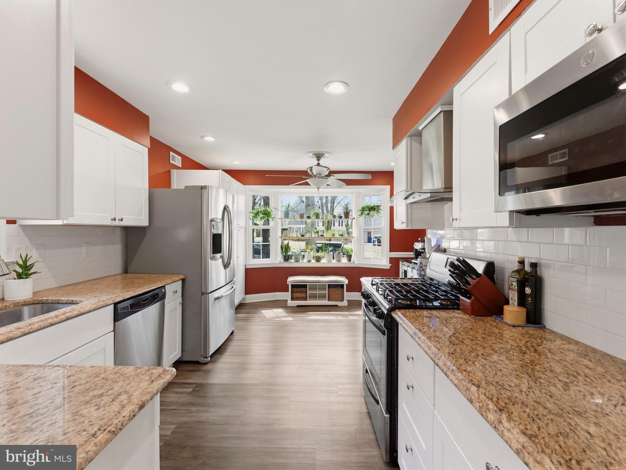 13744 Lockdale Road Silver Spring, MD 20906 - Photo 8 of 37 a kitchen with stainless steel appliances granite countertop a stove a sink and a microwave