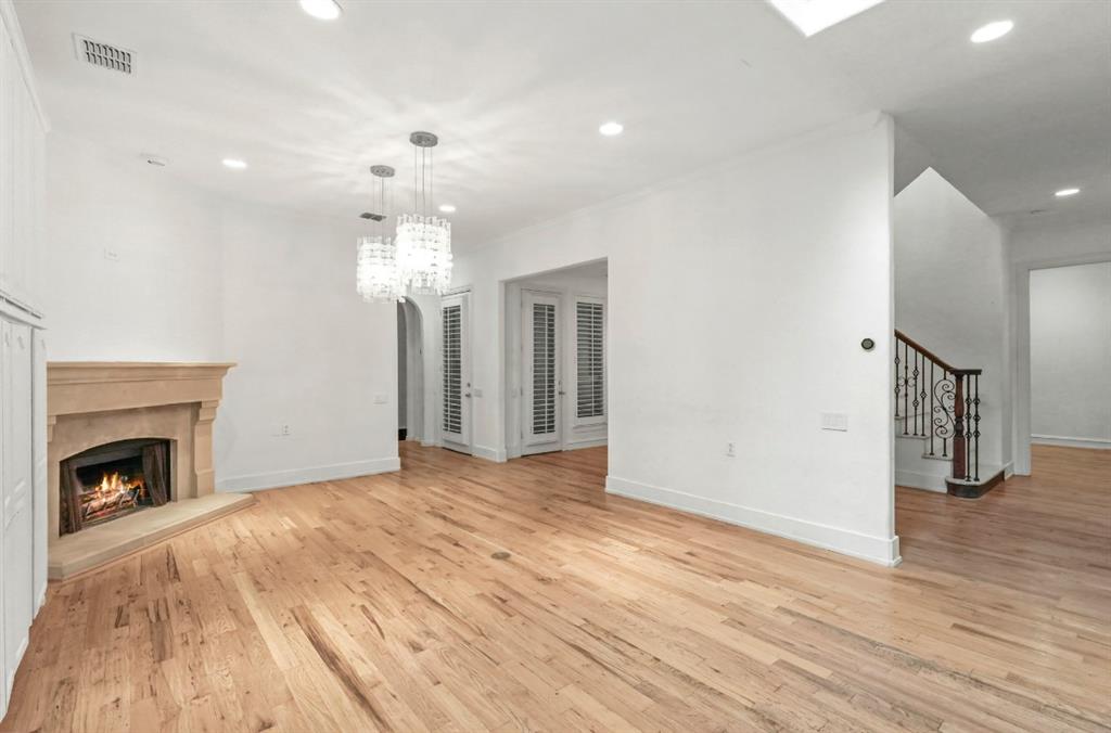 11911 Edgestone Road Dallas, TX 75230 - Photo 10 of 40 a view of empty room with wooden floor and fireplace
