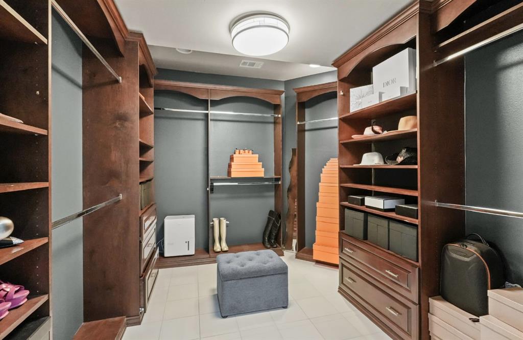 11911 Edgestone Road Dallas, TX 75230 - Photo 24 of 40 a view of walk in closet with clothes and shoes