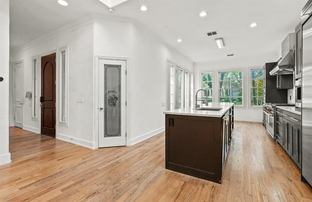 11911 Edgestone Road Dallas, TX 75230 - Photo 6 of 40 a kitchen with stainless steel appliances granite countertop a refrigerator a sink dishwasher a stove and a dining table with wooden floor