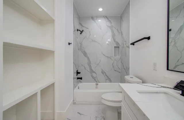 a bathroom with a sink toilet vanity and shower