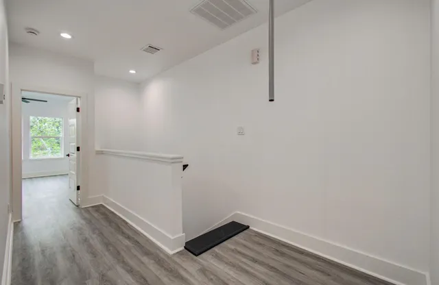 a view of hallway with wooden floor