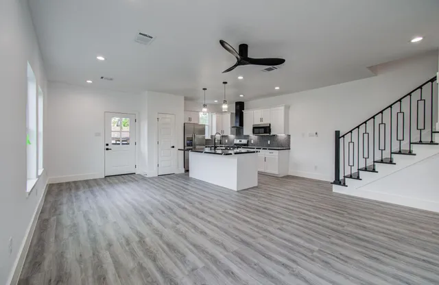 a view of a kitchen with a sink and dishwasher a refrigerator with wooden floor