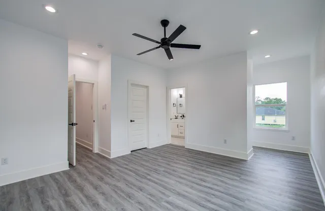 an empty room with wooden floor and windows