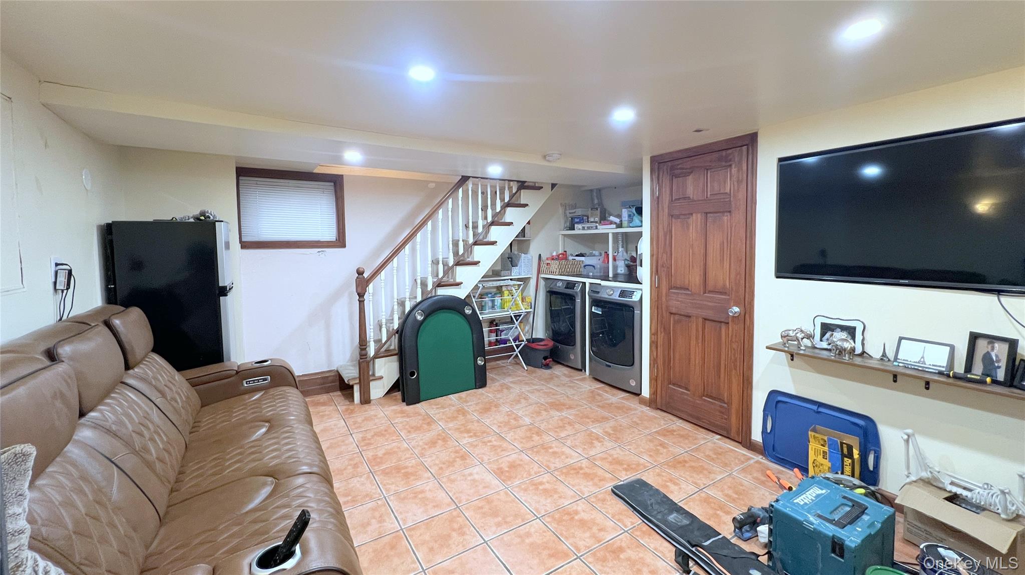 67-31 52nd Road Queens, NY 11378 - Photo 14 of 21 Living area featuring stairs, light tile patterned flooring, and washing machine and dryer