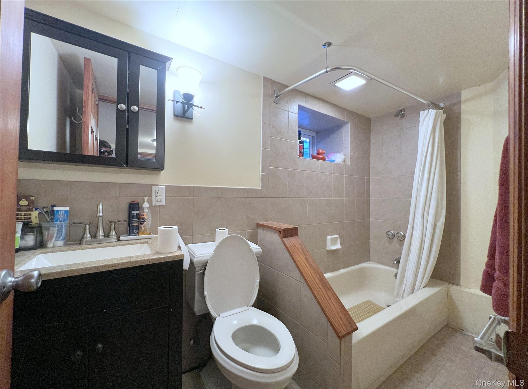 67-31 52nd Road Queens, NY 11378 - Photo 17 of 21 Full bathroom with shower / bathtub combination with curtain, vanity, and tile walls