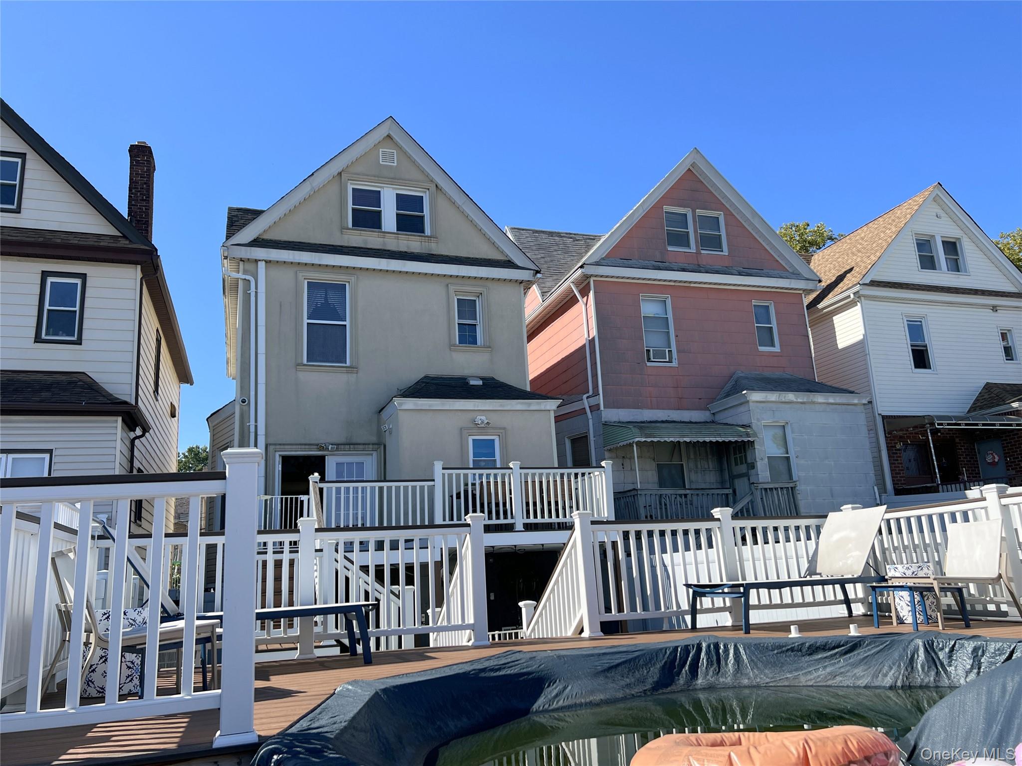 67-31 52nd Road Queens, NY 11378 - Photo 20 of 21 Back of house with a wooden deck, stucco siding, and a residential view