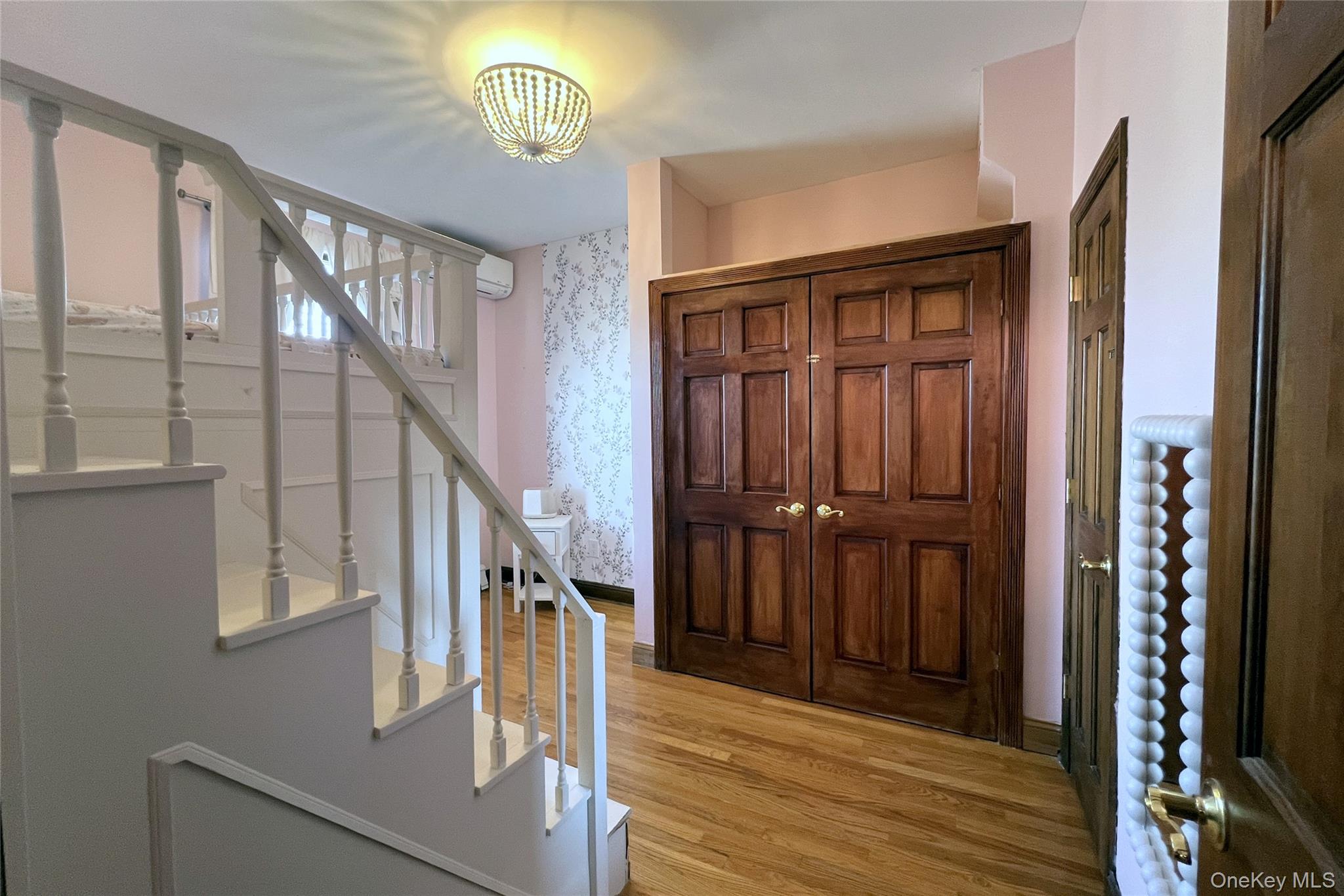 67-31 52nd Road Queens, NY 11378 - Photo 8 of 21 Entryway featuring stairs, light wood finished floors, wallpapered walls, and a wall mounted AC