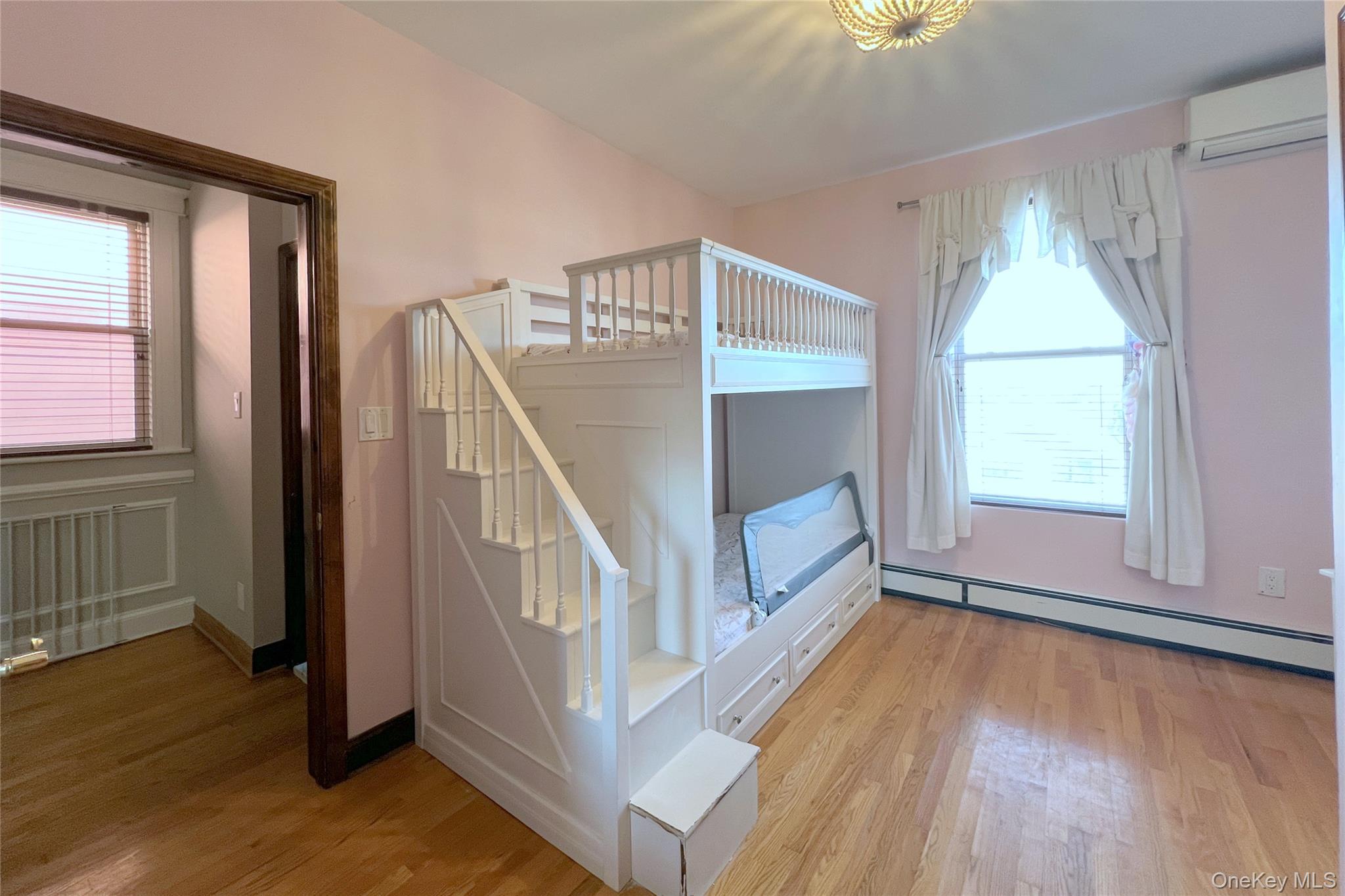 67-31 52nd Road Queens, NY 11378 - Photo 9 of 21 Unfurnished bedroom featuring a baseboard heating unit, light wood-type flooring, and an AC wall unit
