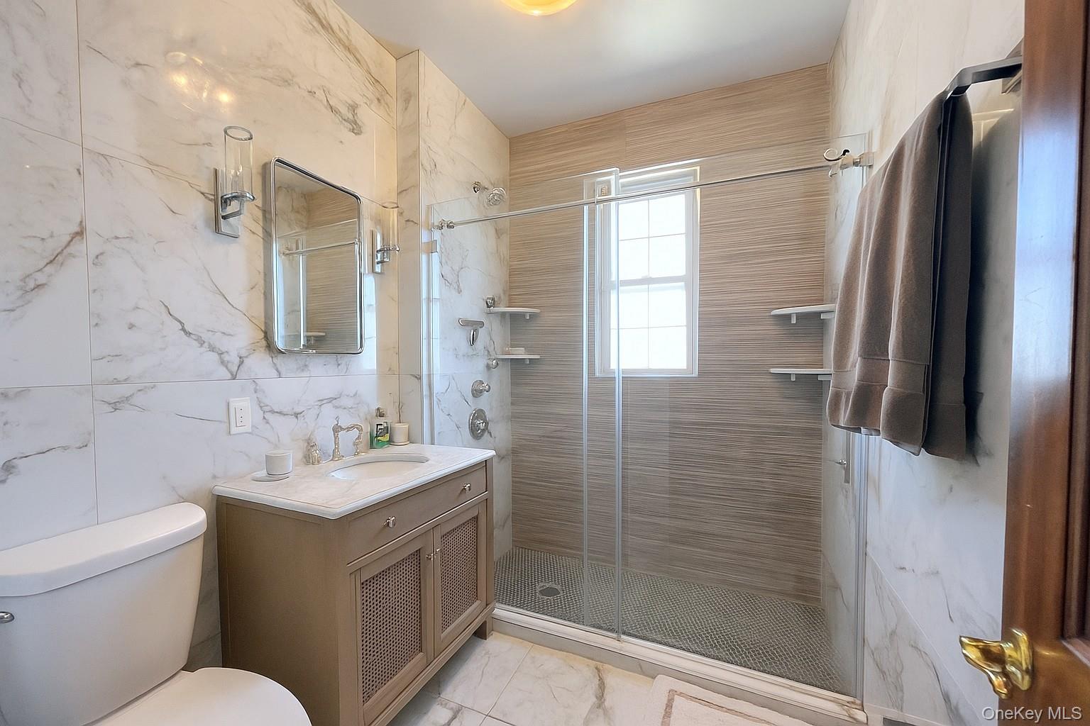 67-31 52nd Road Queens, NY 11378 - Photo 10 of 21 Bathroom with vanity, tile walls, a stall shower, and light marble finish flooring