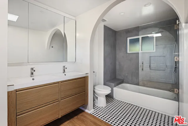 a bathroom with a double vanity sink toilet and shower