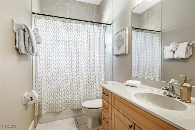a bathroom with a sink a toilet and shower curtain