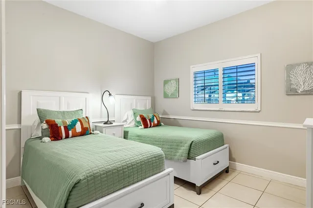 a bedroom with two beds and a window