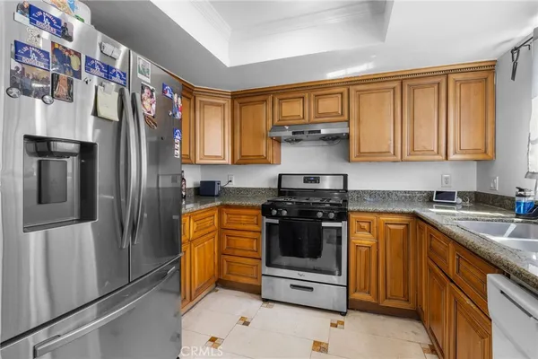 a kitchen with stainless steel appliances granite countertop a refrigerator sink and stove