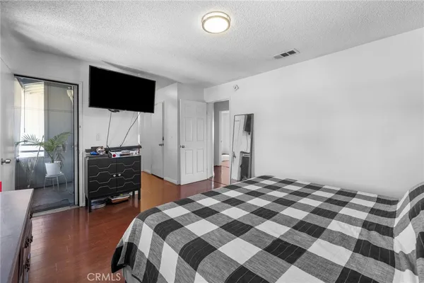 a bedroom with a bed and a flat tv screen on the dresser