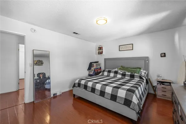 a bedroom with a bed and a lamp with the wooden floor