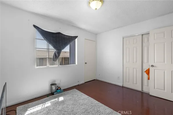 a view of an empty room with wooden floor and cabinet
