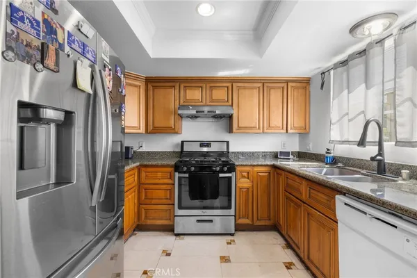 a kitchen with stainless steel appliances granite countertop a stove a sink and a refrigerator
