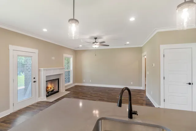 a view of a livingroom with a fireplace wooden cabinet and a chandelier