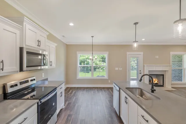 a kitchen with stainless steel appliances granite countertop a sink stove and microwave