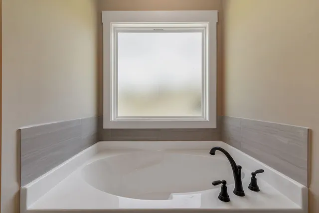 a bathroom with a tub and a window